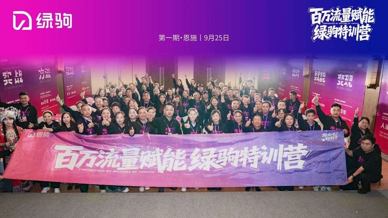 Group photo of participants at the 绿驹百万流量赋能特训营 event, showcasing attendees holding a banner with the event name, emphasizing brand empowerment and traffic growth strategies.